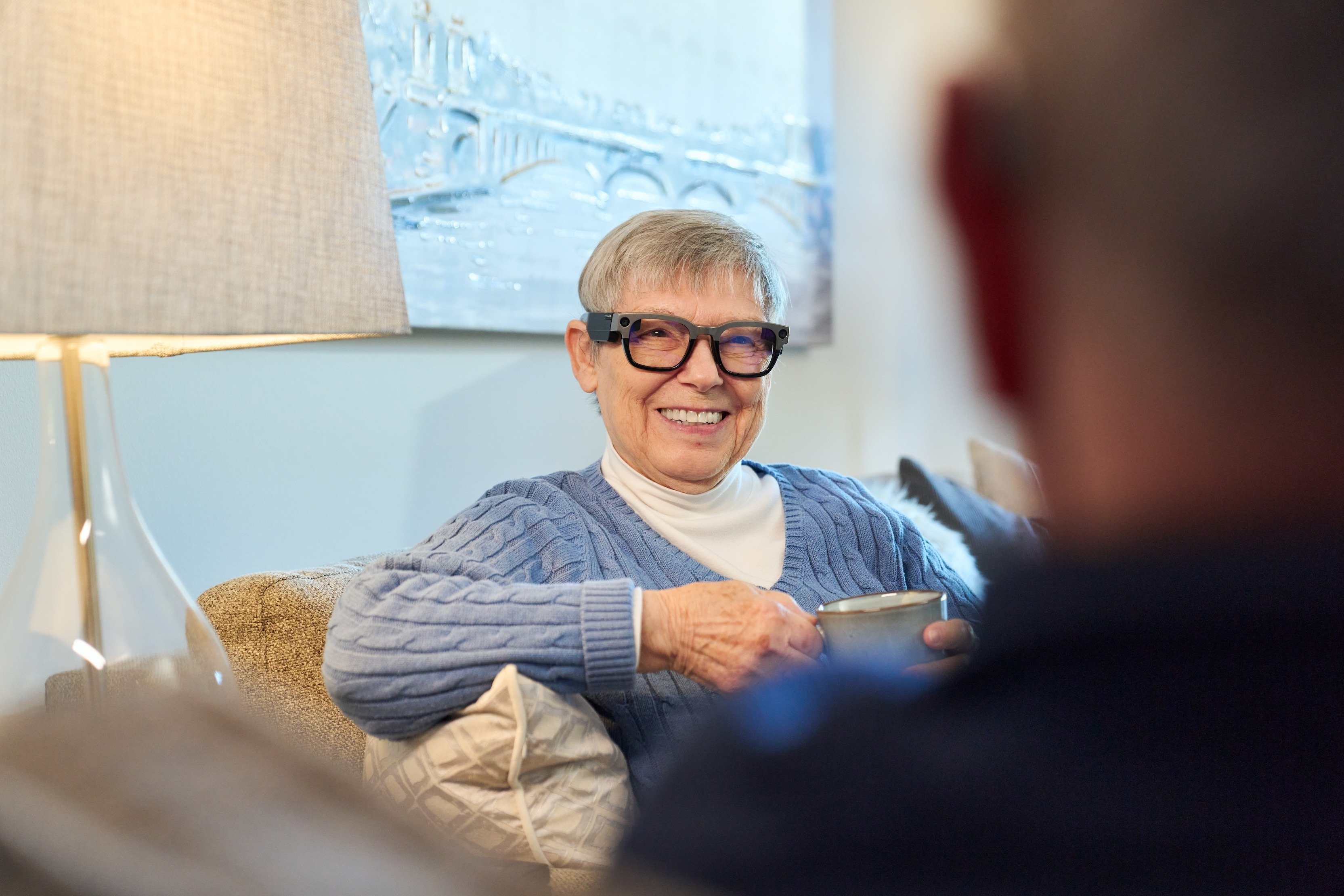 Older woman at Asbury Smart LIving Showcase smiling at man while holding a coffee cup_0460